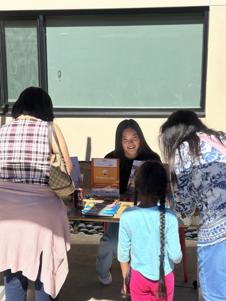 Volunteers greeting families at a community outreach table